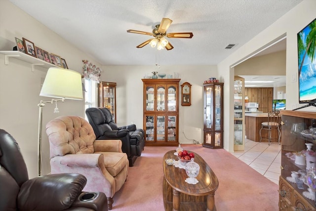 tiled living room featuring ceiling fan and a textured ceiling