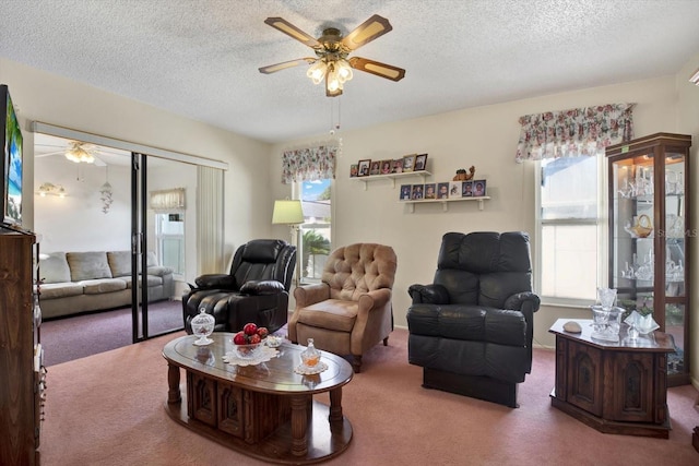 carpeted living room featuring a textured ceiling and ceiling fan