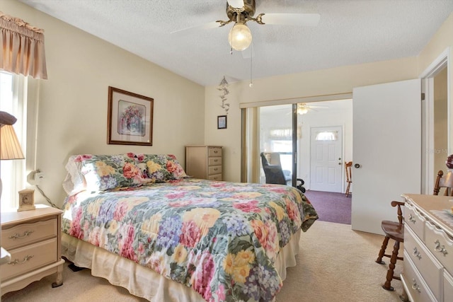 carpeted bedroom featuring multiple windows, ceiling fan, and a textured ceiling