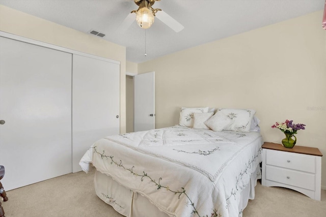 carpeted bedroom with a closet and ceiling fan