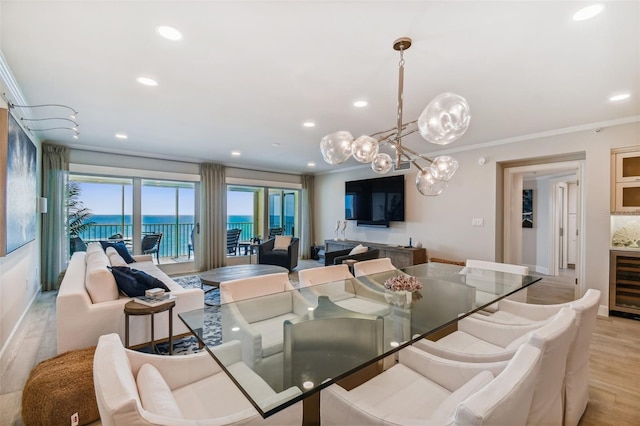 dining area with crown molding, wine cooler, and light hardwood / wood-style floors