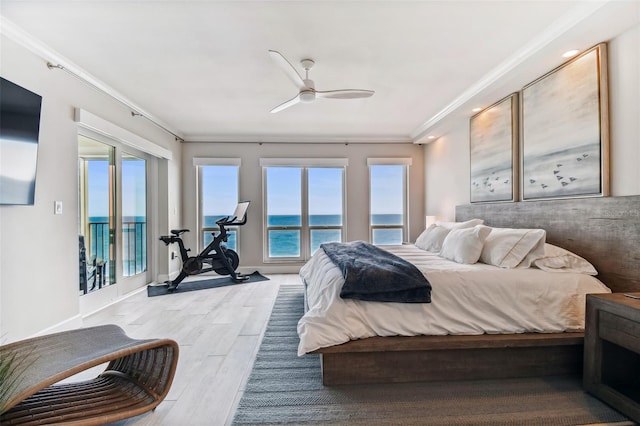 bedroom with ceiling fan, access to exterior, a water view, ornamental molding, and light wood-type flooring