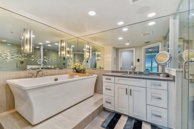 bathroom with a shower with door, vanity, and tile patterned floors