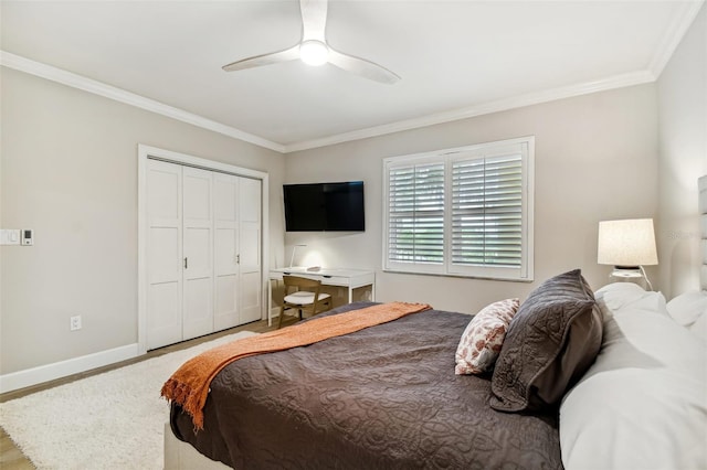 bedroom featuring hardwood / wood-style flooring, ornamental molding, ceiling fan, and a closet