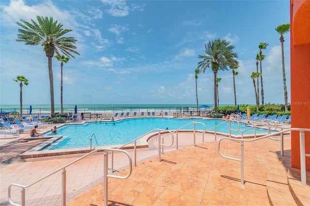 view of pool with a patio area and a water view