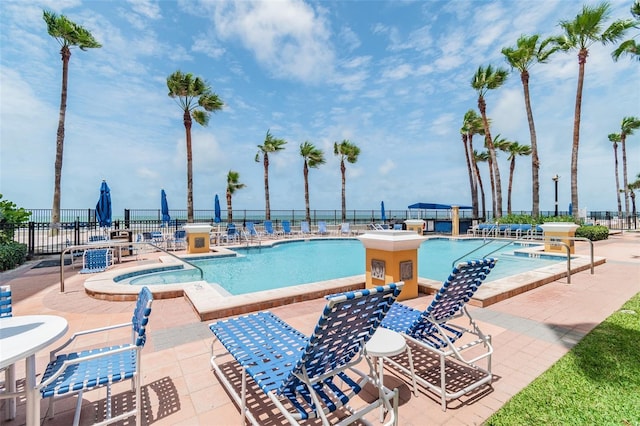 view of swimming pool with a hot tub and a patio area