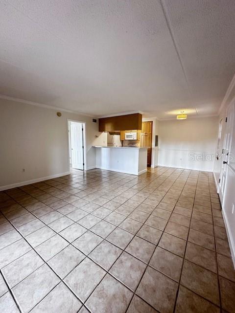 unfurnished living room with ornamental molding, a textured ceiling, and light tile patterned floors