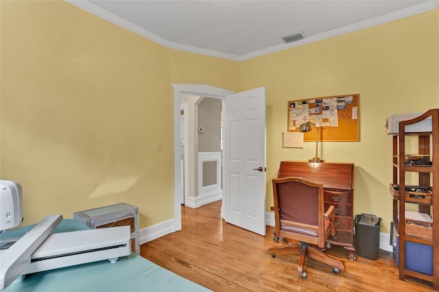 home office with crown molding and light hardwood / wood-style flooring