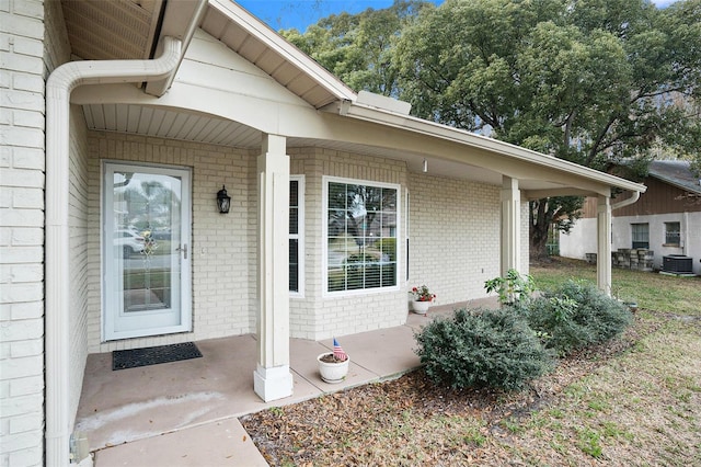 entrance to property with cooling unit and covered porch