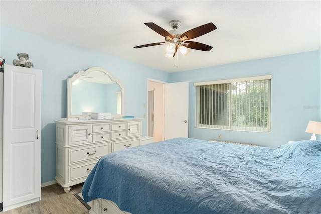 bedroom featuring ceiling fan, a textured ceiling, and light wood-type flooring