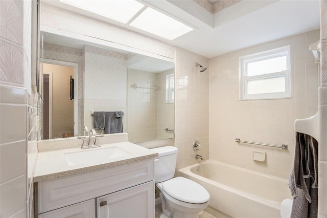 full bathroom with vanity, toilet, and tiled shower / bath combo