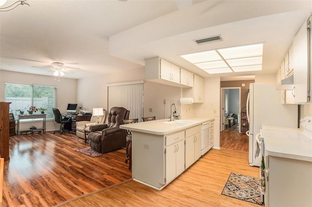 kitchen featuring white cabinetry, sink, dishwasher, and light wood-type flooring