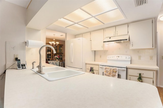 kitchen featuring sink, an inviting chandelier, white appliances, and decorative backsplash