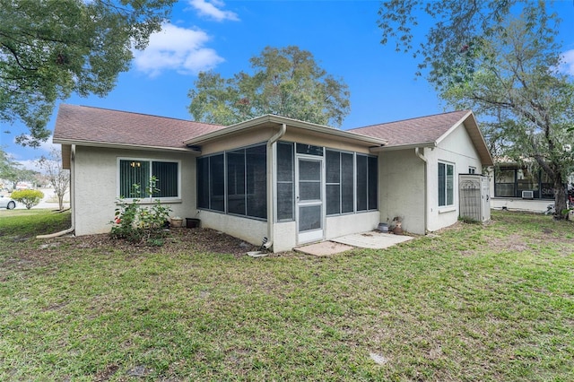 rear view of house with a sunroom and a yard