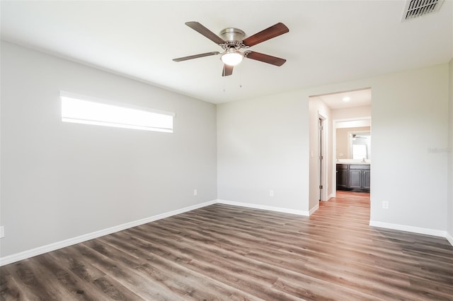 empty room featuring dark wood-type flooring and ceiling fan