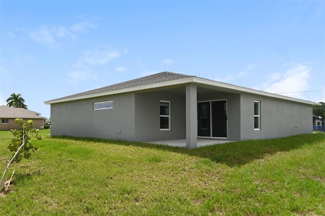 back of property with a patio area and a lawn