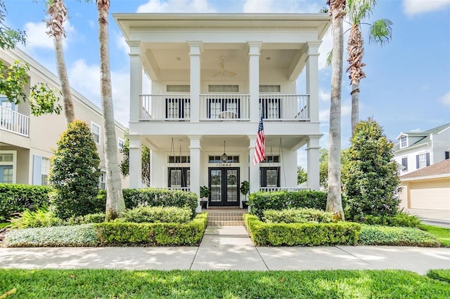 greek revival house featuring a balcony and french doors