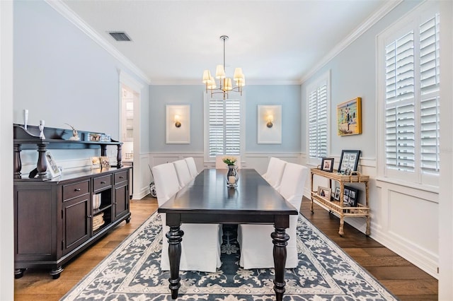 dining space with an inviting chandelier, ornamental molding, and light wood-type flooring