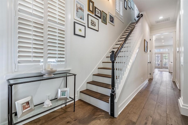 stairs featuring hardwood / wood-style flooring, crown molding, and french doors