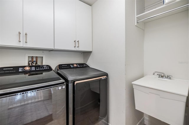 clothes washing area featuring cabinets and washer and dryer