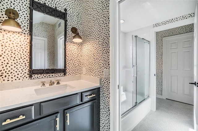 bathroom with tile patterned flooring, enclosed tub / shower combo, and vanity