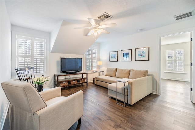 living room with a textured ceiling, wood-type flooring, and ceiling fan