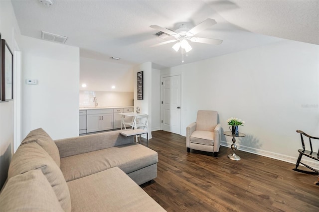 living room with sink, dark wood-type flooring, a textured ceiling, and ceiling fan