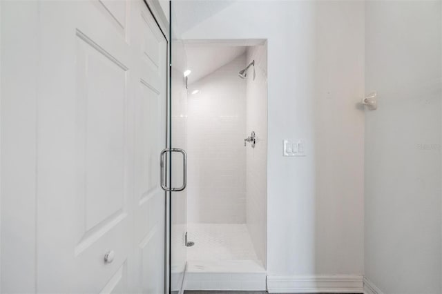 bathroom featuring a shower with door