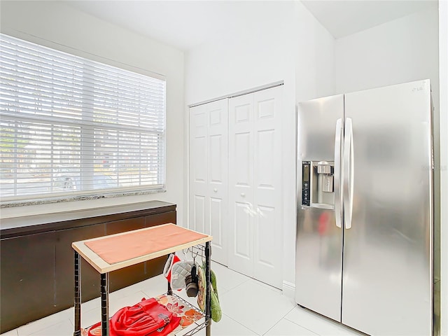 kitchen with stainless steel refrigerator with ice dispenser and light tile patterned flooring