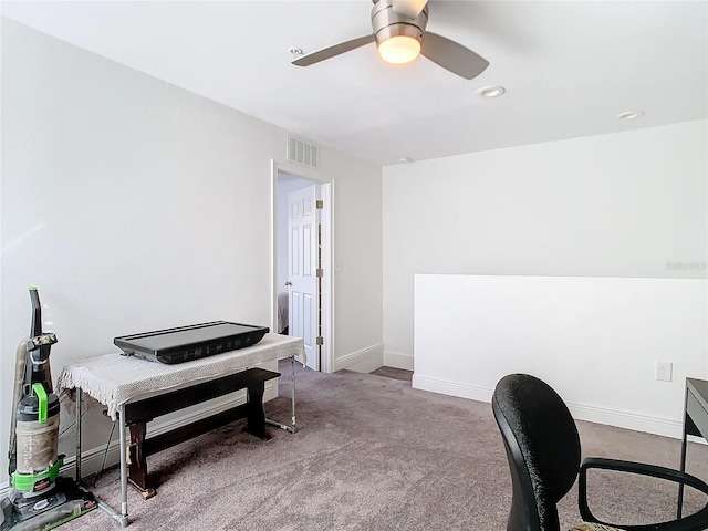 carpeted home office featuring ceiling fan