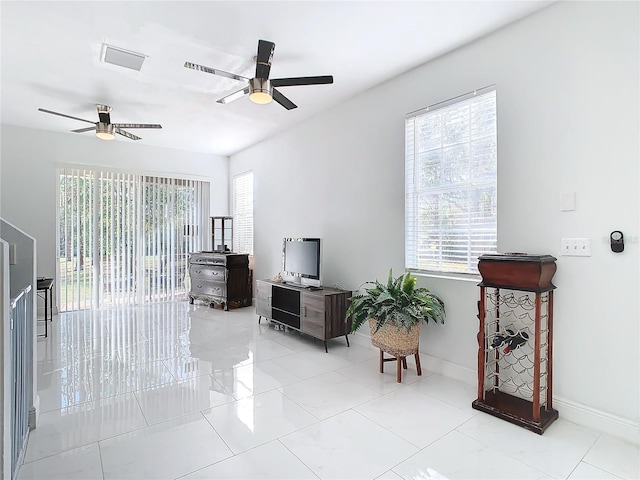 living room featuring ceiling fan and a healthy amount of sunlight