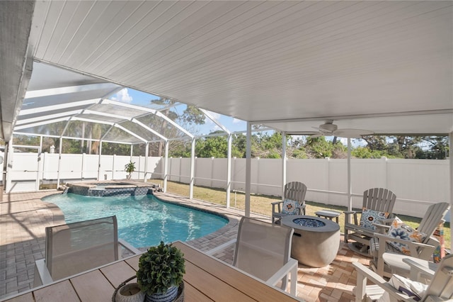 view of swimming pool featuring a fire pit, a patio area, glass enclosure, and an in ground hot tub