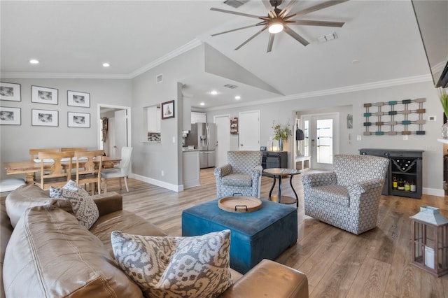 living room featuring french doors, lofted ceiling, crown molding, ceiling fan, and hardwood / wood-style floors