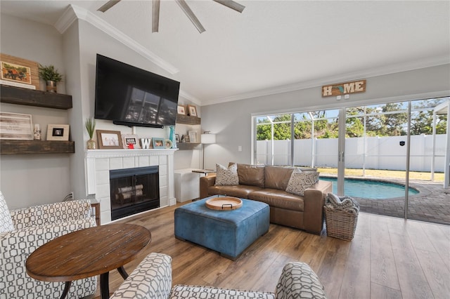 living room featuring a tiled fireplace, hardwood / wood-style flooring, and ornamental molding