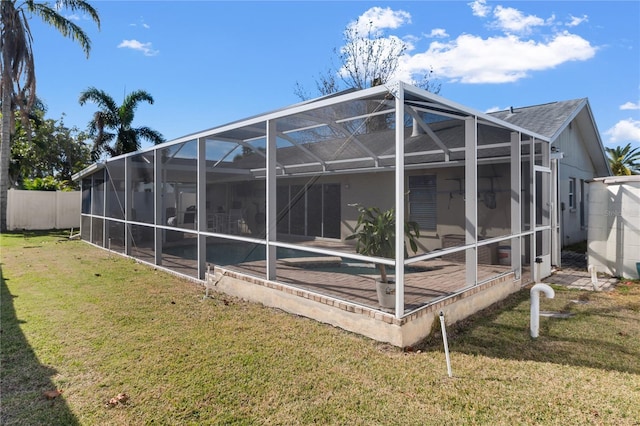 rear view of house with a pool, a lanai, and a lawn