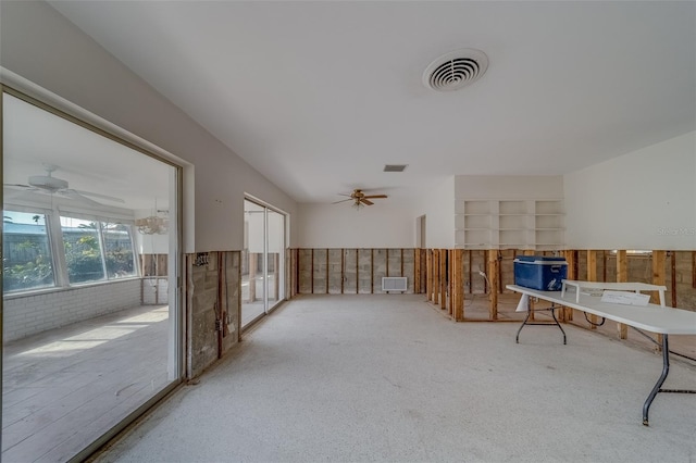 interior space featuring brick wall, built in features, and ceiling fan