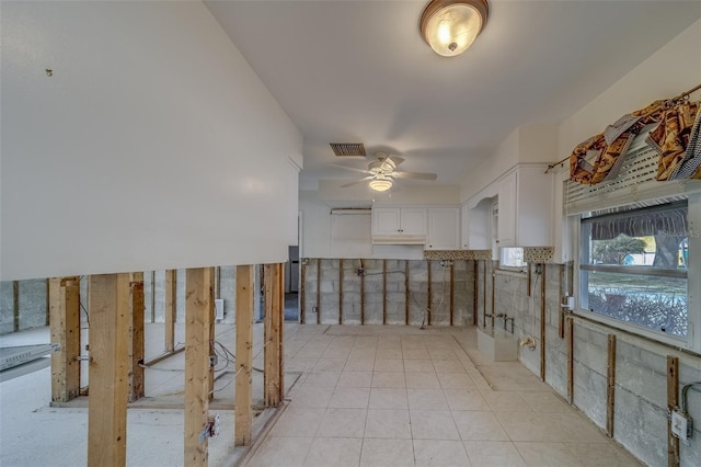 interior space with white cabinetry, light tile patterned flooring, and ceiling fan