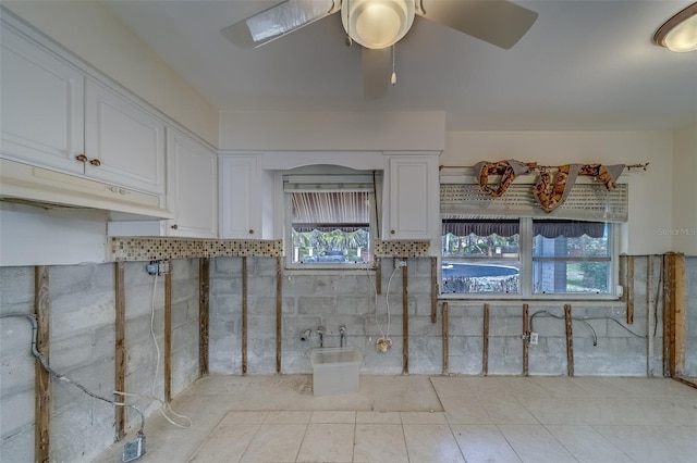 kitchen featuring ceiling fan, white cabinets, and light tile patterned flooring