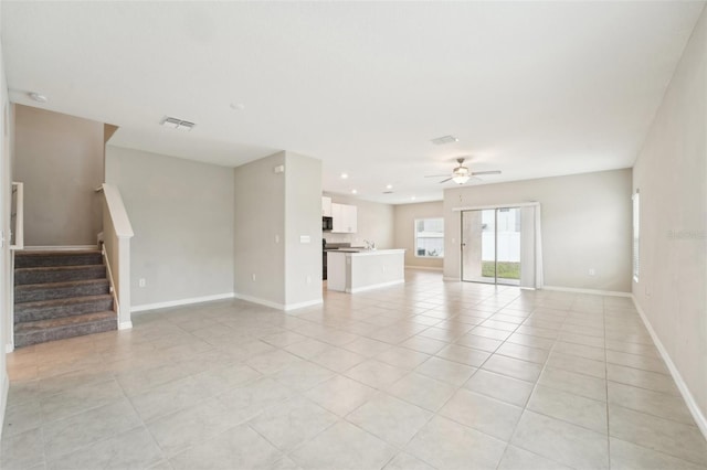 empty room featuring light tile patterned flooring, ceiling fan, and sink