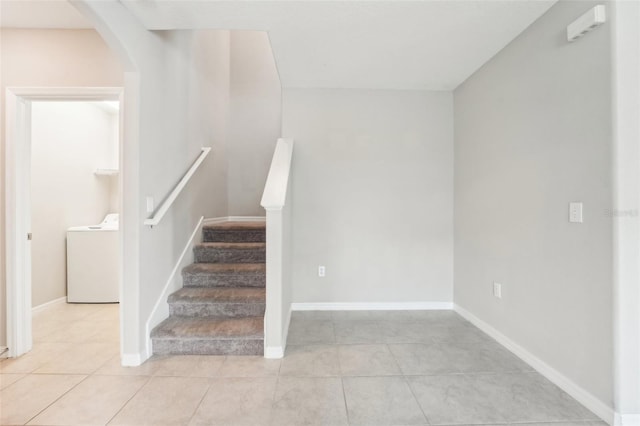 stairway with washer / clothes dryer and tile patterned floors