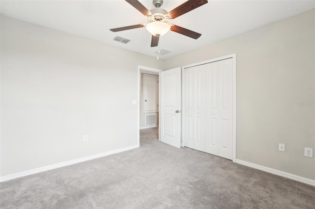 unfurnished bedroom featuring light carpet, ceiling fan, and a closet