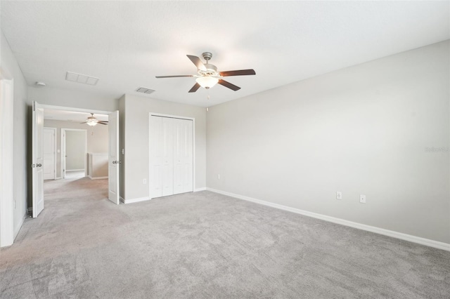 unfurnished bedroom with light colored carpet, a closet, and ceiling fan