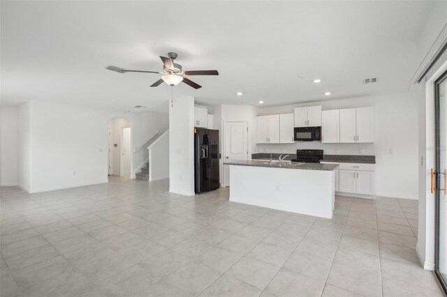 kitchen featuring arched walkways, visible vents, white cabinets, open floor plan, and black appliances