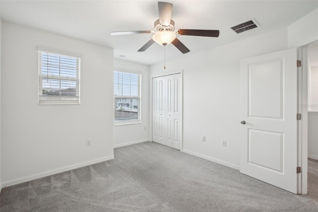 unfurnished bedroom featuring carpet, a closet, visible vents, and baseboards