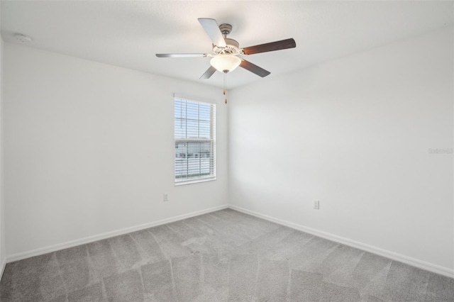 carpeted empty room with baseboards and a ceiling fan