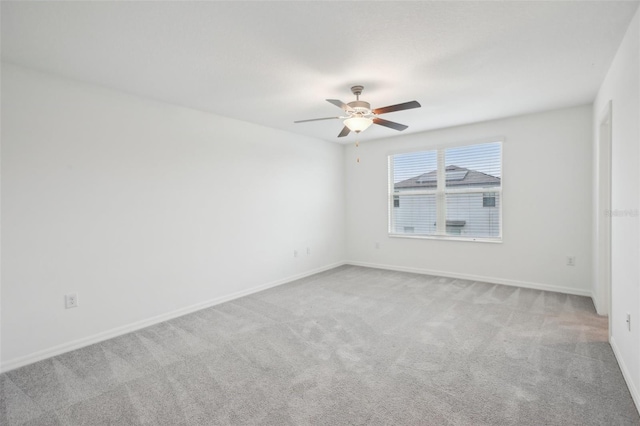 empty room with carpet floors, baseboards, and a ceiling fan