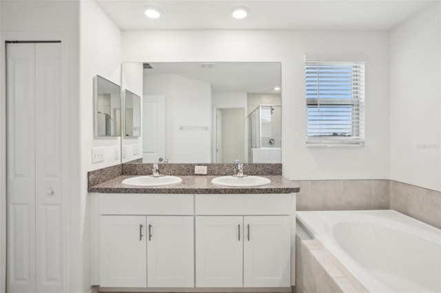 full bath featuring a closet, a sink, and a bath