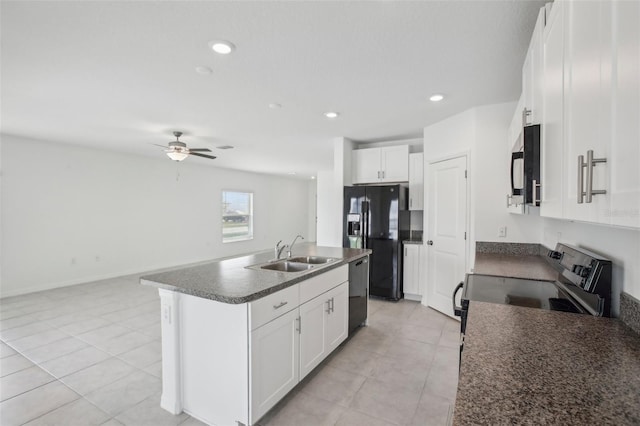 kitchen with a center island with sink, dark countertops, white cabinetry, a sink, and black appliances