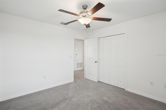 unfurnished bedroom with a closet, visible vents, a ceiling fan, carpet flooring, and baseboards