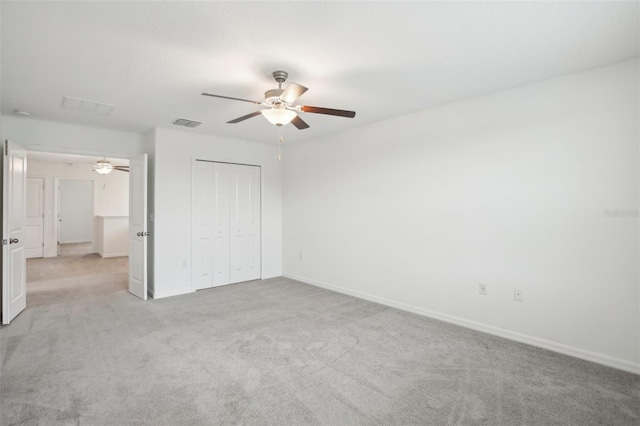 unfurnished bedroom featuring ceiling fan, carpet floors, visible vents, baseboards, and a closet